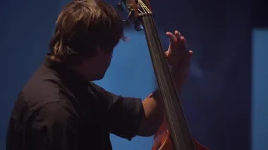 Erkek çellocu, karanlıkta sahnede çello çalıyor. Kyiv. Ukrayna