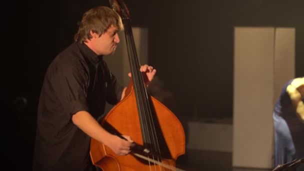 Männlicher Cellist, der im Dunkeln auf der Bühne Cello spielt. Kiew. Ukraine — Stockvideo