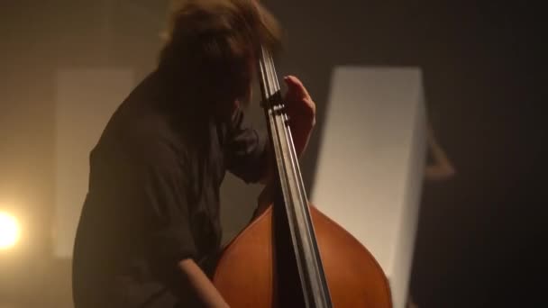 Mužský violoncellista hrající na violoncello ve tmě na jevišti. Kyjev. Ukrajina — Stock video