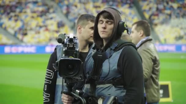 Cameraman com uma câmera no estádio durante um jogo de futebol. Televisão — Vídeo de Stock