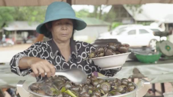 Piac Sihanoukville-ben. Kambodzsa. Ázsiában. A nő főtt csigát árul. — Stock videók