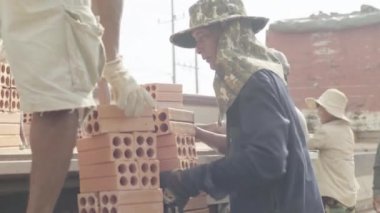 İşçiler tuğla taşır. Sihanoukville, Kamboçya, Asya