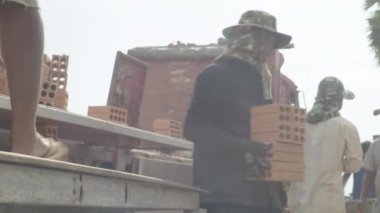 İşçiler tuğla taşır. Sihanoukville, Kamboçya, Asya