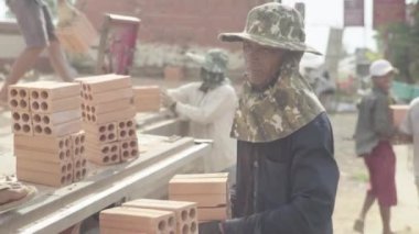 İşçiler tuğla taşır. Sihanoukville, Kamboçya, Asya