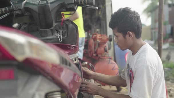 Facet myje motocykl. Phnom Penh, Kambodża, Azja — Wideo stockowe