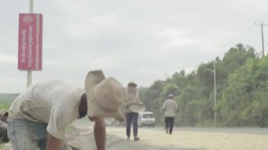 Otoyol kenarında yol işçileri var. Sihanoukville, Kamboçya, Asya.