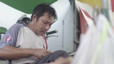 Phnom Penh, Kamboçya, Asya 'da bir adam ayakkabı tamir ediyor.