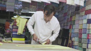 Erkek bir terzi kumaşla çalışır. Phnom Penh, Kamboçya, Asya