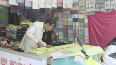 Erkek bir terzi kumaşla çalışır. Phnom Penh, Kamboçya, Asya