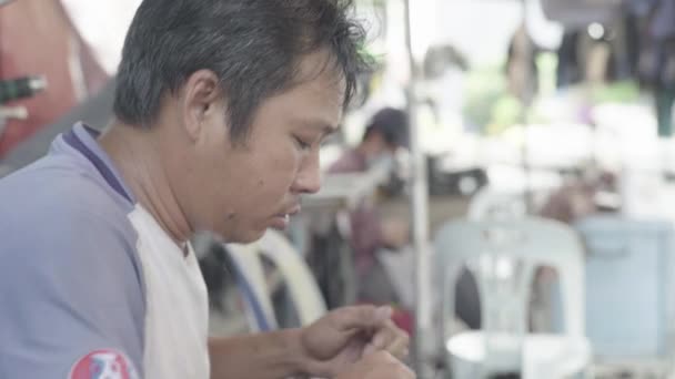 A man repairs shoes on a street of Phnom Penh, Cambodia, Asia — Stock Video