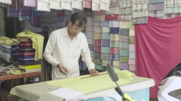 Un sastre masculino trabaja con un paño. Phnom Penh, Camboya, Asia — Vídeos de Stock