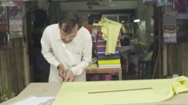 Erkek bir terzi kumaşla çalışır. Phnom Penh, Kamboçya, Asya