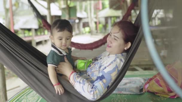 Een vrouw met haar baby rust in een hangmat. Sihanoukville, Cambodja, Azië. — Stockvideo