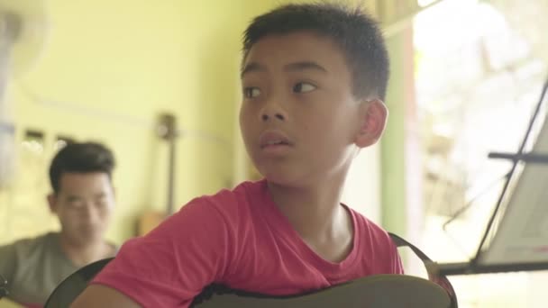 Музыкальная школа в Пномпене, Камбодия, Азия. Ученик учится играть на гитаре — стоковое видео