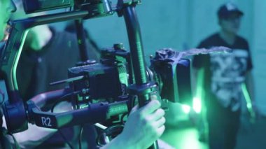 Çekim sırasında elinde kamera olan bir kameraman. Film yapımcılığı. Çekim.