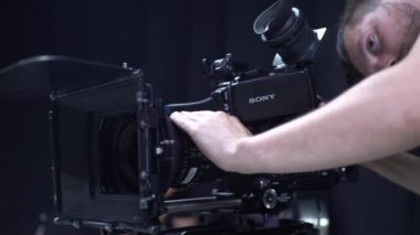 Çekim sırasında elinde kamera olan bir kameraman. Film yapımcılığı. Çekim.