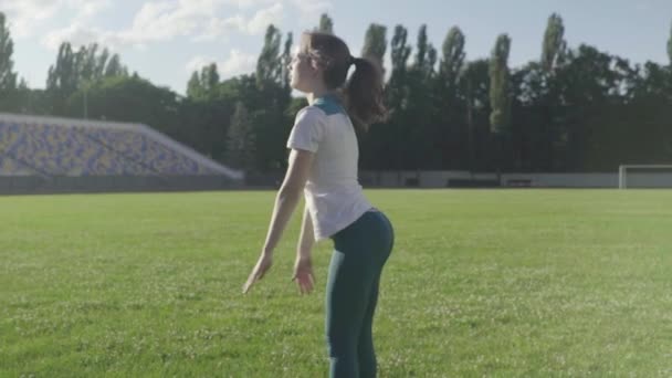 Flickidrottare som gör gymnastik på stadion. Långsamma rörelser — Stockvideo