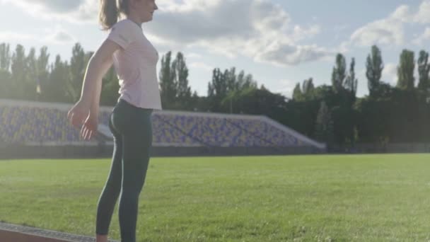 Pige atlet laver gymnastik på stadion. Langsom bevægelse – Stock-video