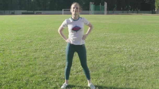 Meisje atleet doet gymnastiek in het stadion. Langzame beweging — Stockvideo