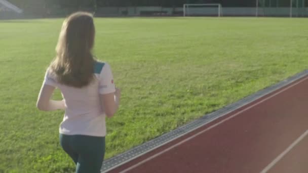 En atletisk ung flicka springer på stadion. Långsamma rörelser — Stockvideo