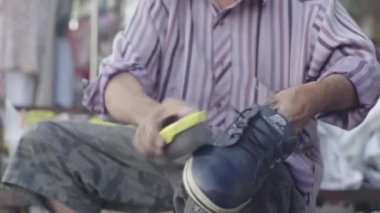 Kamboçya 'da günlük yaşam. Asya. Bir adam sokakta ayakkabı temizliyor. Ayakkabı temizleyici.