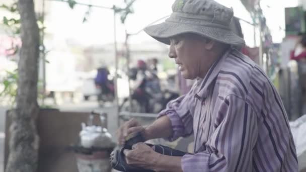 Denní život v Kambodži. Asie. Muž na ulici čistí boty. Čistič bot — Stock video