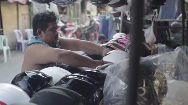 A vida diária no Camboja. Ásia. Motocicleta capacete vendedor no mercado — Vídeo de Stock