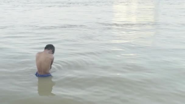 Alltag in Kambodscha. Asien. Ein Mann badet im Mekong — Stockvideo