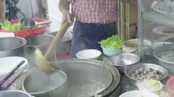 Щоденне життя в Камбоджі. Азія. Чоловік готує вуличну їжу в Пномпені. — стокове відео