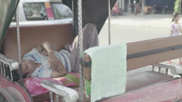 Dagelijks leven in Cambodja. Azië. Rickshaw chauffeur slaapt in een riksja — Stockvideo