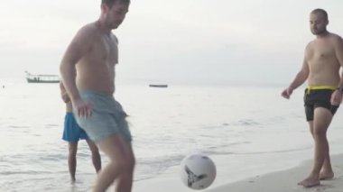 İnsanlar Sihanoukville, Kamboçya, Asya sahillerinde futbol oynuyor.