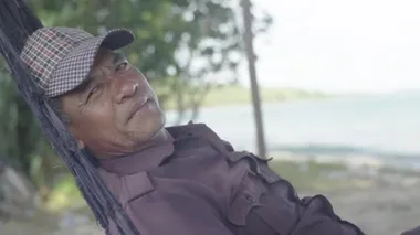 Kamboçya 'da günlük yaşam. Asya. Bir adam deniz kenarındaki bir hamakta dinleniyor.