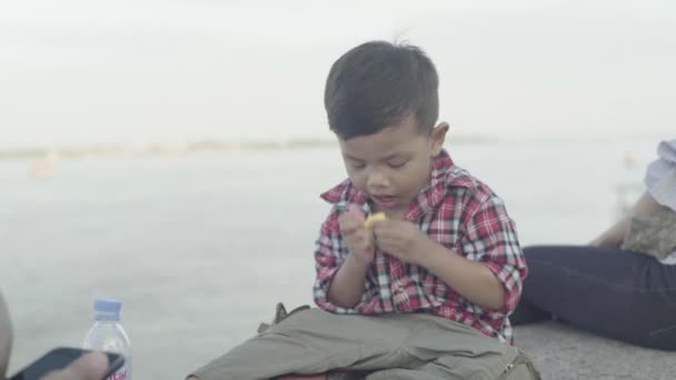 Seorang anak makan buah di tepi Sungai Mekong. Phnom Penh, Kamboja, Asia — Stok Video