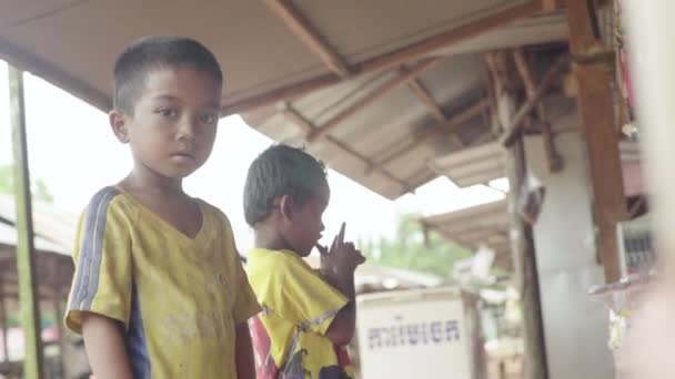 Sokakta arkadaşlarıyla çevrili bir çocuk. Sihanoukville, Kamboçya, Asya. — Stok video