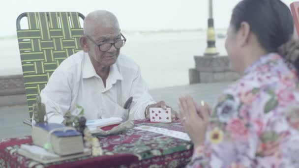Det dagliga livet i Kambodja. Asien. Fortune-teller man gissar på att spela kort på gatan i Phnom Penh stad — Stockvideo