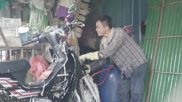 A vida diária no Camboja. Ásia. O tipo lava uma mota — Vídeo de Stock