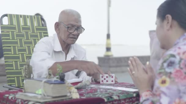 La vida cotidiana en Camboya. Asia. Hombre adivino adivinando jugando cartas en la calle de la ciudad de Phnom Penh — Vídeos de Stock