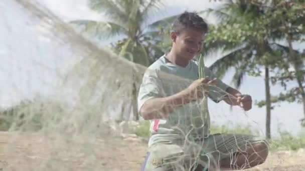 Un pescatore sta sistemando una rete da pesca sulla spiaggia di Sihanoukville. Cambogia. Asia — Video Stock