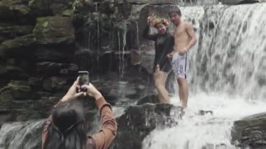 Şelalenin yanında fotoğraf çekimi. Sihanoukville, Kamboçya, Asya. Suda poz veren bir kızla adam.