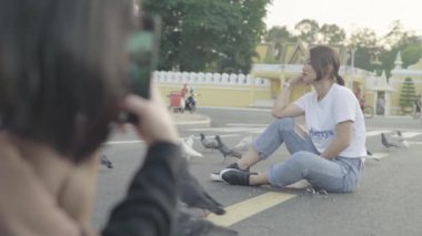 Phnom Penh, Kamboçya, Asya 'nın bir caddesinde oturan bir kızın fotoğrafı çekiliyor.