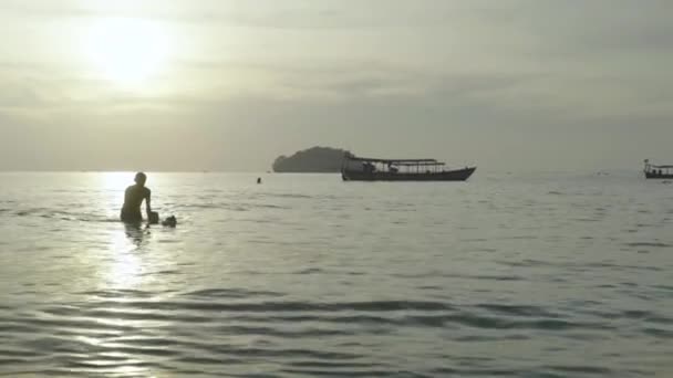 ชายหาดในสีหนุวิลล์ กัมพูชา เอเชีย พ่อกับลูกชายและสุนัขว่ายน้ําในทะเล — วีดีโอสต็อก