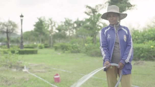 Verkligt folkliv i Kambodja: En kvinna slangar gräs. Det är Phnom Penh. Asien — Stockvideo