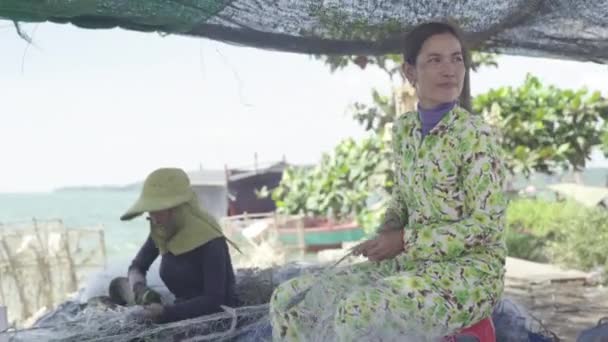 女性がカンボジアのシアヌークビルで漁網を修理する — ストック動画
