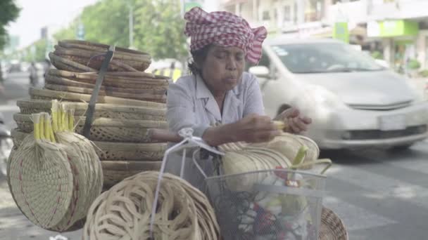 한 연로 한 여자가 캄보디아의 프놈펜 거리에서 바나나를 먹고 있다 — 비디오
