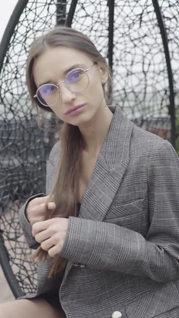 Pionowe wideo. Piękna dziewczyna w okularach i szarym garniturze. Zwolniony ruch — Wideo stockowe