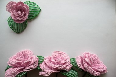 Gri arkaplandaki boncuklardan güller. Boncuklu arka plan.