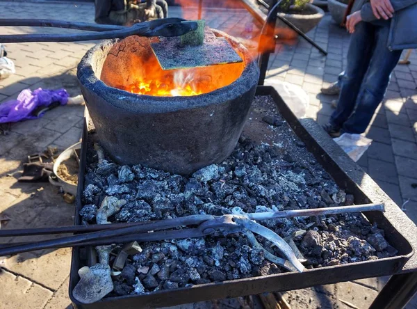 Hot coals in a brazier and metal forging tools.
