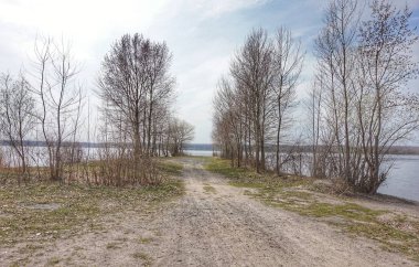Bahar başında nehir kıyısında. Uzaktan bir köprü görülebilir. Avrupa.
