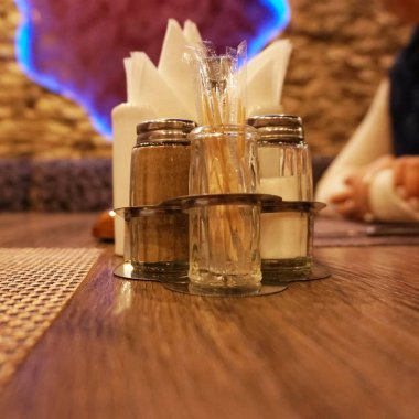 Lokantada masanın üzerinde duran cihazlar: tuzluk, biberlik ve peçeteler için ayakta durun..