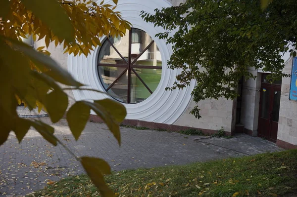 Ungewöhnliches Rundes Fenster Und Ein Zweig Mit Gelben Herbstblättern — Stockfoto